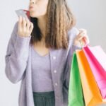 Mulher com sacolas de compras e cartão de crédito com cashback
