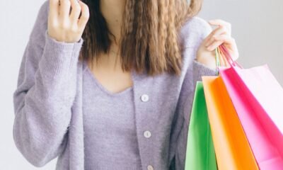Mulher com sacolas de compras e cartão de crédito com cashback