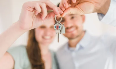 Casal feliz segurando chave da casa própria após financiamento