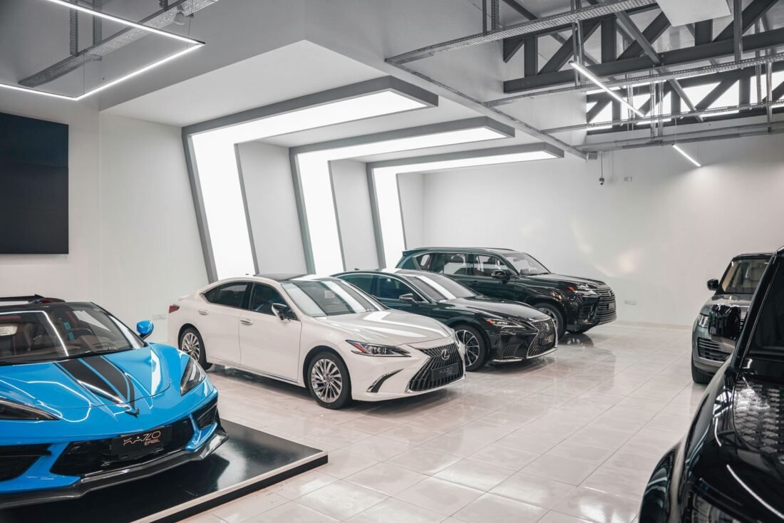 Fila de carros novos em pátio de concessionária, representando a compra por consórcio de veículos Fila de carros novos em pátio de concessionária, representando a compra por consórcio de veículos