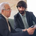 Consultor mostrando documento de aposentadoria para cliente