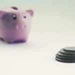 Moedas e cofrinho representando investimento e diversificação de renda
