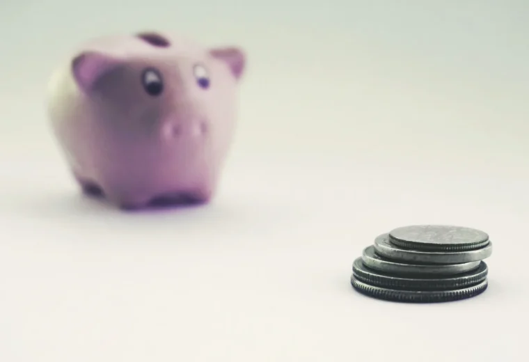 Moedas e cofrinho representando investimento e diversificação de renda