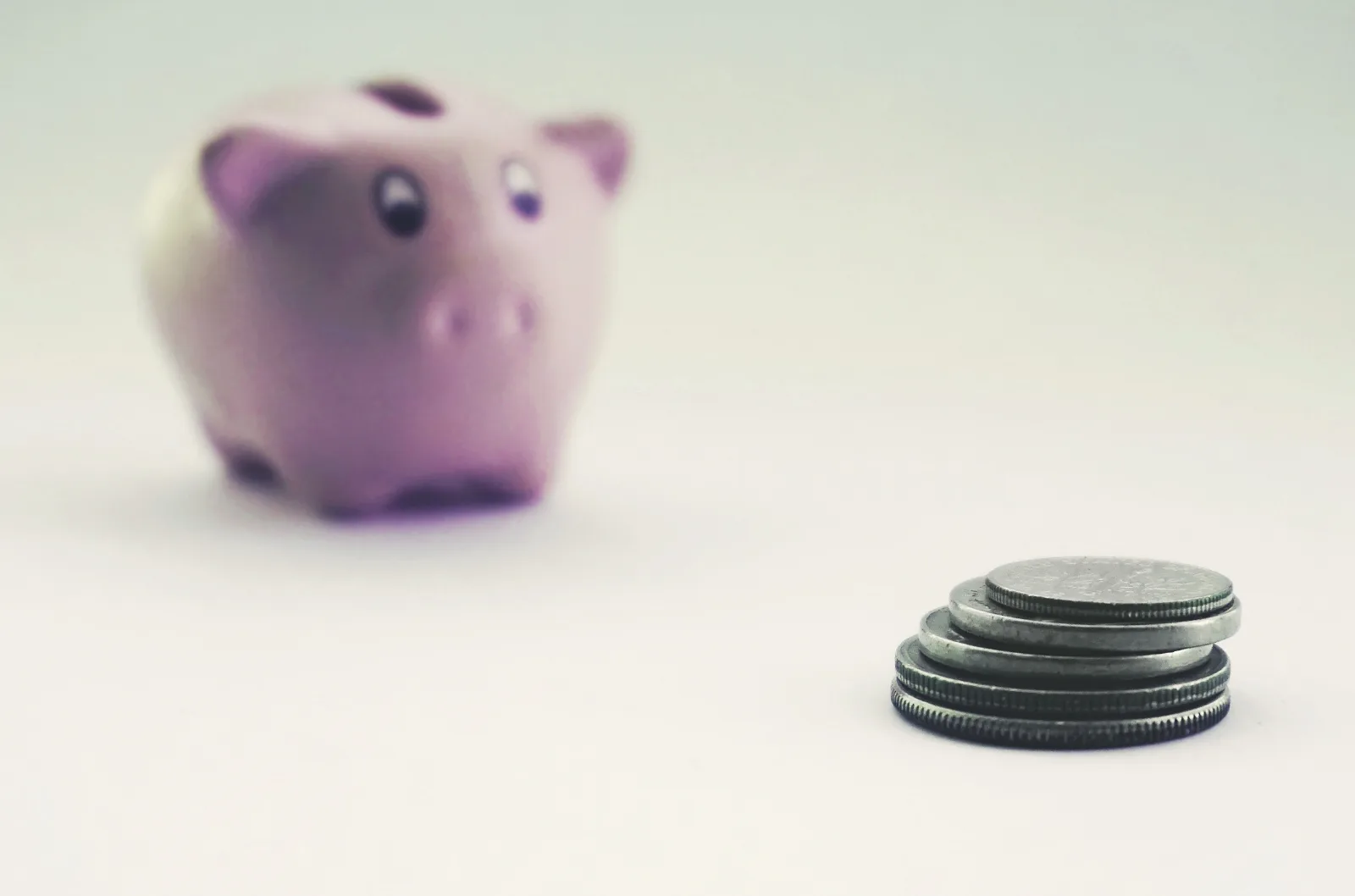Moedas e cofrinho representando investimento e diversificação de renda