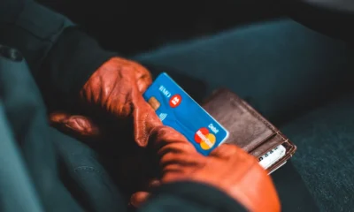 Pessoa segurando cartão de crédito azul e branco