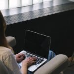 Mulher trabalhando em notebook em ambiente residencial, representando trabalho freelancer como renda extra online