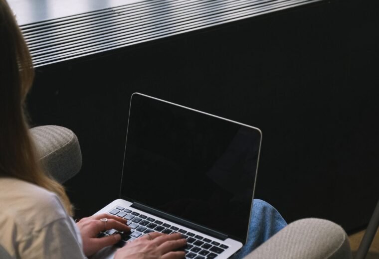 Mulher trabalhando em notebook em ambiente residencial, representando trabalho freelancer como renda extra online