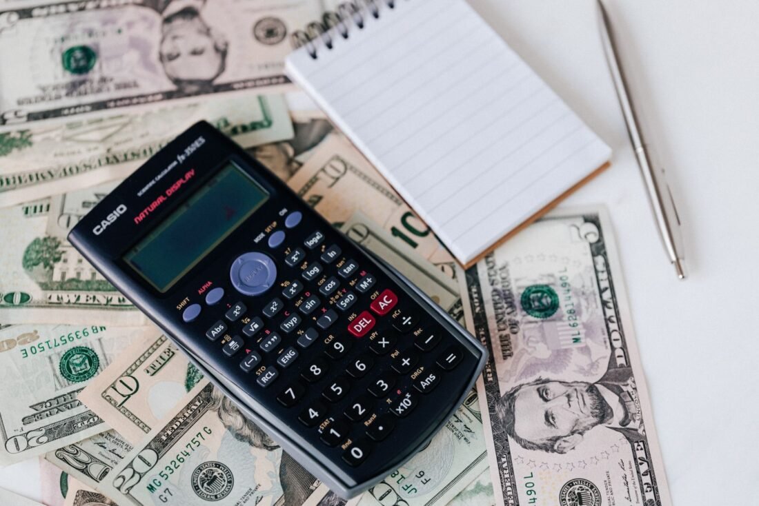 Documentos de dívida e calculadora sobre a mesa, representando a organização financeira de quem busca empréstimo com nome sujo