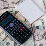 Documentos de dívida e calculadora sobre a mesa, representando a organização financeira de quem busca empréstimo com nome sujo