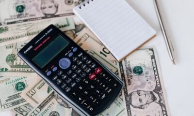 Documentos de dívida e calculadora sobre a mesa, representando a organização financeira de quem busca empréstimo com nome sujo