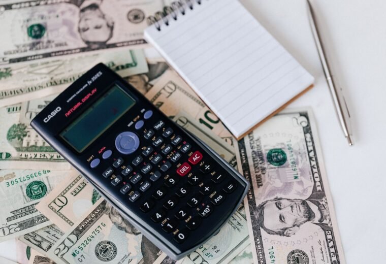 Documentos de dívida e calculadora sobre a mesa, representando a organização financeira de quem busca empréstimo com nome sujo