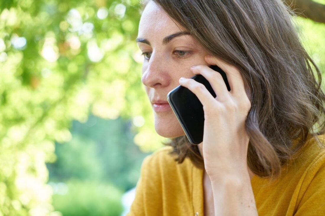 Mão segurando celular e digitando, representando a participação em grupos de WhatsApp de renda extra