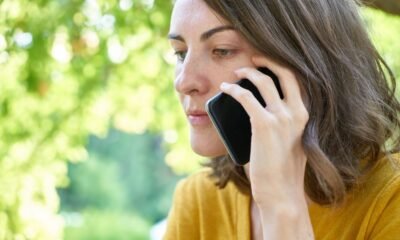 Mão segurando celular e digitando, representando a participação em grupos de WhatsApp de renda extra