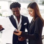Cliente e consultora lendo os detalhes de um contrato de financiamento de veículo em uma concessionária