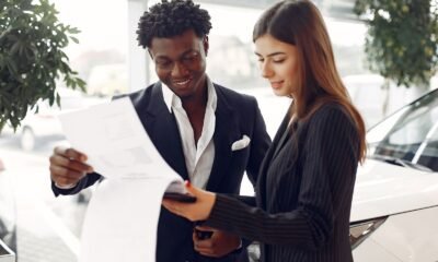 Cliente e consultora lendo os detalhes de um contrato de financiamento de veículo em uma concessionária