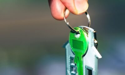 Mão segurando chaveiro em formato de casa, representando a simulação do financiamento da casa própria