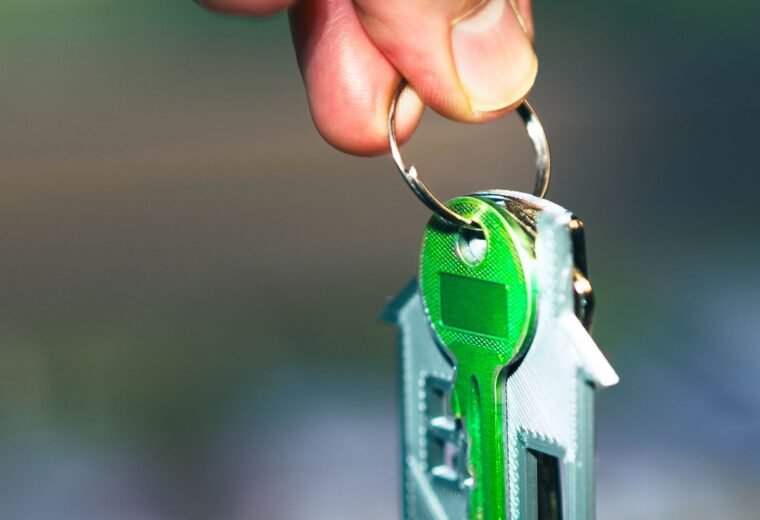 Mão segurando chaveiro em formato de casa, representando a simulação do financiamento da casa própria