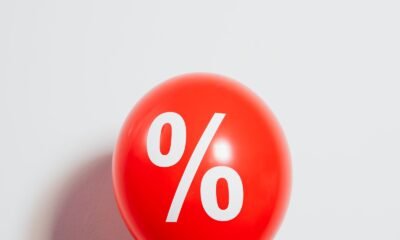 Moedas de ouro ao lado de um símbolo de porcentagem, representando a taxa de juros do financiamento